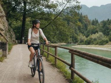 Začetnik kolesar na treking kolesu na slikoviti kolesarski poti ob reki s čelado in sproščeno držo